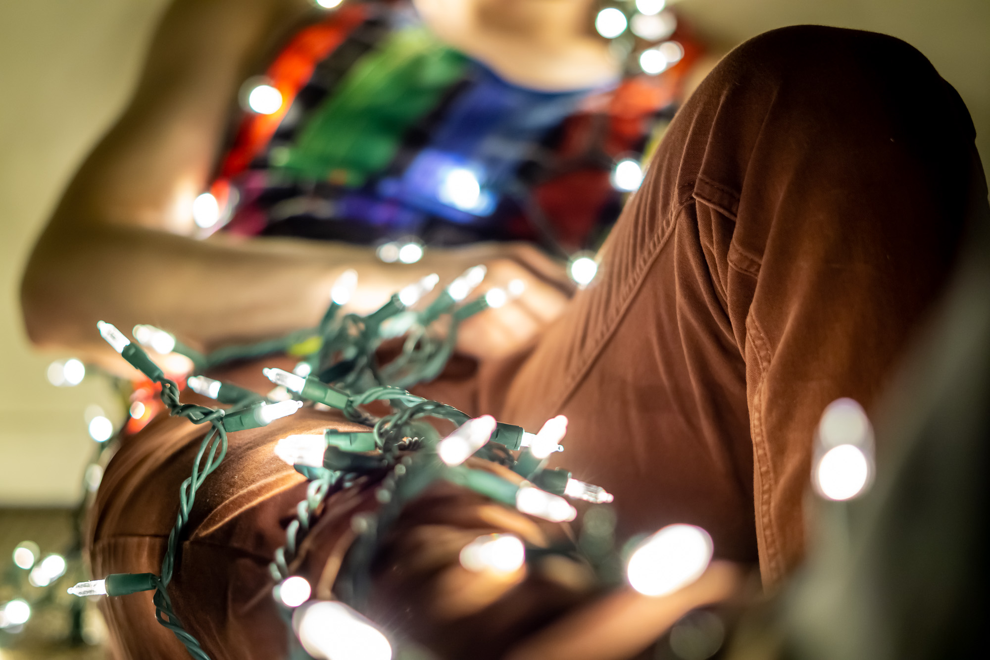 Person wrapped in Christmas lights